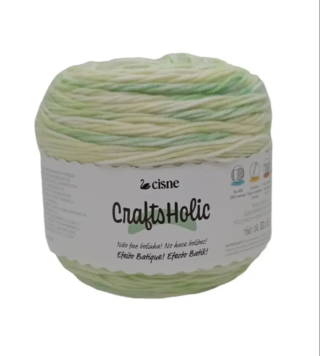Ovillo de lana acrilica Cisne CraftsHolic en tonos pastel verde y crema con efecto batik, ideal para tejido.