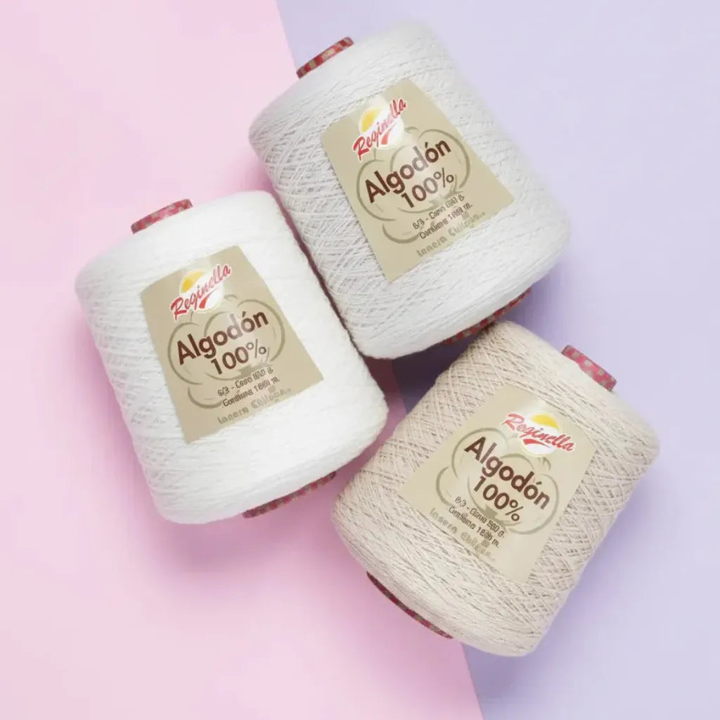 Tres conos de hilo Reginella 100% algodón en tonos crema y beige claro para tejer, ganchillo o macramé.