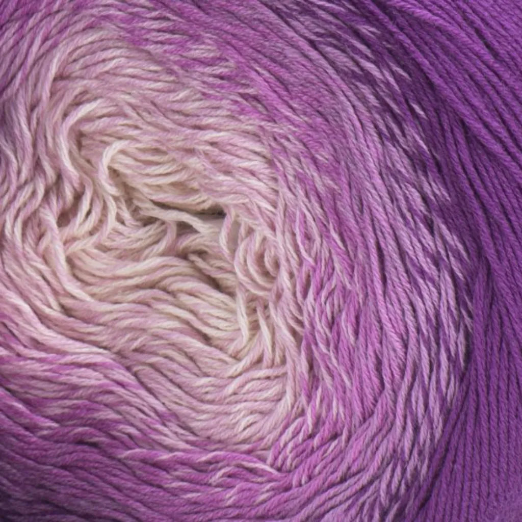 Ovillo de hilo degradado de algodón y acrílico, tonos beige, lila y morado en espiral.