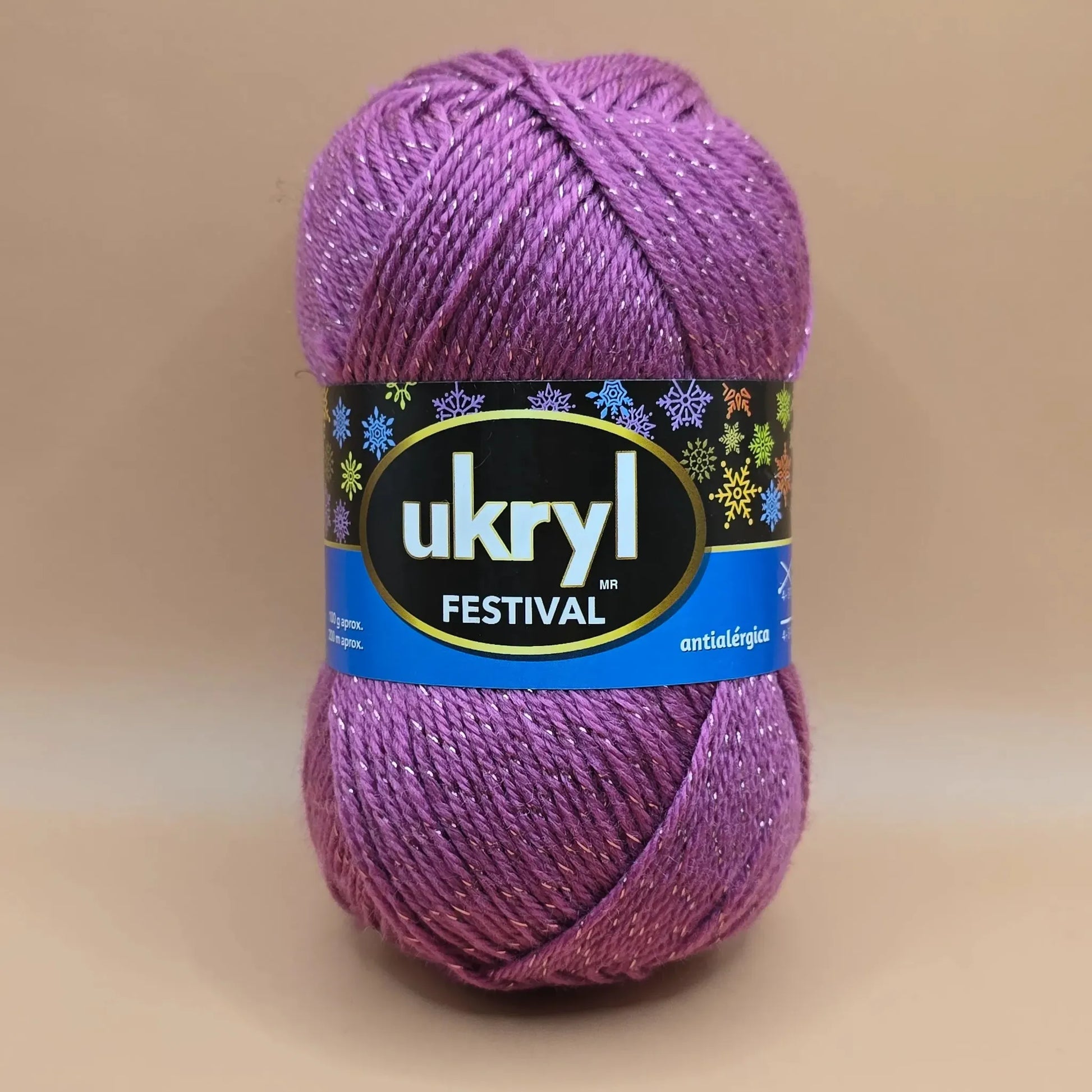 Ovillo de lana Ukryl Festival morado intenso con brillo plateado Lurex, ideal para tejer prendas y accesorios antialérgicos.
