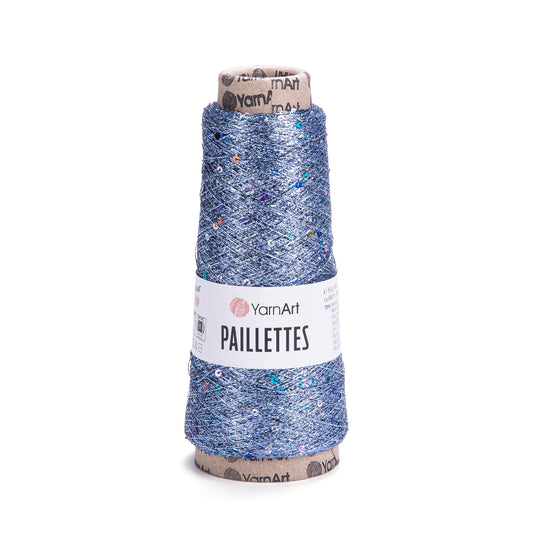 Cono de hilo YarnArt Paillettes azul metalico con lentejuelas brillantes multicolores sobre fondo blanco.